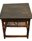 Dark lacquered bamboo side table with bamboo-style legs and frame, antique finish, studio background.