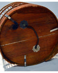 Brown wooden and metal antique Chinese bird cage with circular base and handle, resting on its side.