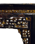 Black lacquered Chinese altar table with hand-carved floral and geometric designs, gold and red accent details.