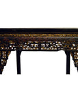 Black lacquer wood altar table with carved details and gold and red accents on edges and legs.