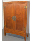 Brown lacquered wood Chinese cabinet with double doors and round brass lock, set on a gray floor.