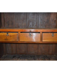 Brown lacquered wood cabinet with three closed drawers and metal handles, antique style.