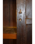 Close-up of brown lacquered wood Chinese cabinet with a scratched door, damaged lock, and empty interior.