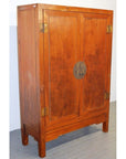 Brown lacquer antique Chinese wood cabinet with double doors on a gray floor, front view.