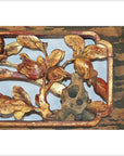 Gold and brown gilt lacquer wood panel with blooming magnolia carving, ornate gold-painted details, close-up view.