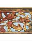 Close-up of antique Chinese wood carving panel with gold and red magnolia flowers, branches, and leaves on light background.
