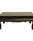 Close-up of dark wood Indonesian carved table with gold accents and curved, hand-carved lion’s paw legs.