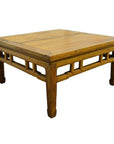 Light brown lacquered wood square Chinese coffee table with carved stretcher, shown on white background.
