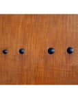 Close-up of antique wooden Chinese door with natural patina, featuring four black metal studs in a row.