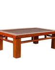 Brown Chinese elm coffee table with square legs and rattan inset top on plain white background.