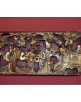 Gold gilt wood carving with ornate Chinese figures, trees, and architectural details in a garden scene, close-up view.