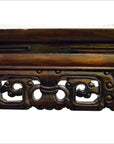 Close-up of dark wood hand carved console or altar table with ornate, intricate patterns and detailed craftsmanship.