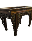 Dark wood hand-carved Chinese console or altar table with ornate floral frame and spandrels, no tabletop shown.
