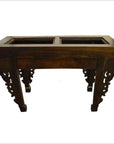 Dark wood console or altar table with carved spandrels and two rectangular cutouts, hand-carved, antique style.