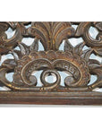 Brown lacquered rosewood wall plaque with symmetrical hand carved Chinese floral and leaf patterns, close-up.