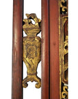 Close-up of gold gilt scrollwork on antique Chinese wooden architectural panel with multi-figure scene decoration.