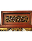 Close-up of red lacquer and gilt wood antique Chinese carved panel with intricate courtyard scene relief carvings.