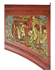 Red wood sign with gold relief of three Chinese figures in traditional dress, carved details visible on the panel.