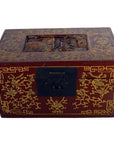 Black lacquered Chinese box with central latch and embossed stylized birdwork, ornate gilt design on lid, close-up.