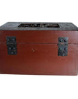 Black lacquered box with central latch and stylized bird design on lid, antique, shown in plain setting.