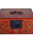 Close-up of antique Chinese lacquer box with gold phoenix and vine motifs, black clasp, and carved oval on lid.