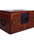Black and gold lacquered Chinese box with phoenix motif, gilt vine patterns, black metal handles, and front latch, close-up.