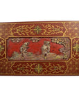 Red and gold Chinese lacquer box with floral inlay and raised scene of two figures under trees, close-up view.
