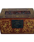 Close-up of antique Chinese lacquer box with gold floral designs, black clasp, and carved dancing figures on lid.