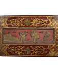 Red and gold lacquered Chinese antique box with raised relief scene of people and birds, close-up view.