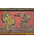 Red and gold lacquer box with hand-carved figure in yellow robe, bird, and rock on raised top.