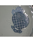 Close-up of blue and white embossed porcelain plate with hand painted Chinese patterns on white background.