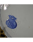 Blue and white porcelain plate with hand-painted pitcher motif and embossed rim, close-up view.