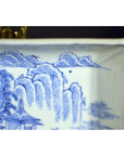 Blue and white porcelain tray close-up featuring landscape with pavilion and willow trees, antique style.