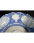 White ceramic scalloped dish with elegant rim featuring a crouching mouse and barrel cartouche, close-up view.