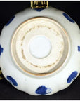 White ceramic scalloped dish with blue accents, featuring a crouching mouse and barrel cartouche, close-up view.