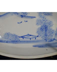 White ceramic boat-shaped dish with misty landscape design and two flying birds, close-up.