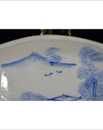 Close-up of antique ceramic boat-shaped dish with painted misty landscape and two flying birds design.