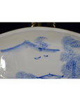 Close-up of antique ceramic boat-shaped dish with painted misty landscape and two flying birds design.