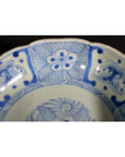 White porcelain bowl with butterfly cartouches and petal-shaped rim, antique Chinese style, close-up view.