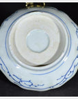White porcelain bowl with butterfly cartouches and petal rim, shown from the bottom, antique Chinese style.