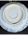 White porcelain bowl with butterfly cartouches and petal rim, shown from the bottom, antique Chinese style.