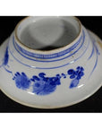 White porcelain Asian deep plate with broad blue rim and minimal center, delicate patterns, bottom view, close-up.