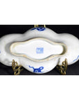 Blue ceramic cloud-form dish with river view and figural scene, shown upside down on brass stand revealing maker's mark.