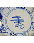 Close-up of blue Chinese characters on antique hand-painted porcelain plate, Longevity & Crab design.