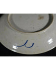 White porcelain underside close-up with blue double curved mark near the base.