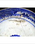 Close-up of blue ceramic Antique Radial Medallion Plate with cracks, dirt, and detailed Inner Sunburst pattern.