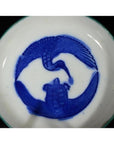 White ceramic plate with antique crane and turtle design, both animals facing each other, close-up view.