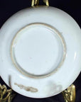 Close-up of worn underside of antique ceramic crane and turtle dish on ornate gold display stand.