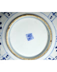 White porcelain plate base with blue painted patterns and a blue central square mark, close-up.