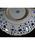 Blue and white porcelain plate underside with hand painted patterns and a central square hallmark.